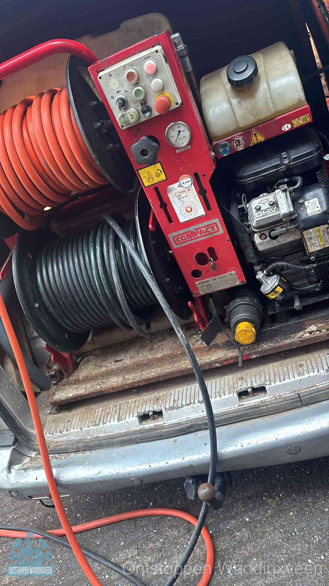 Een rood hogedruk-rioolreinigingstoestel met slangen in de laadbak van de bedrijfsbus, apparatuur voor een hardnekkige wc-verstopping in Waddinxveen