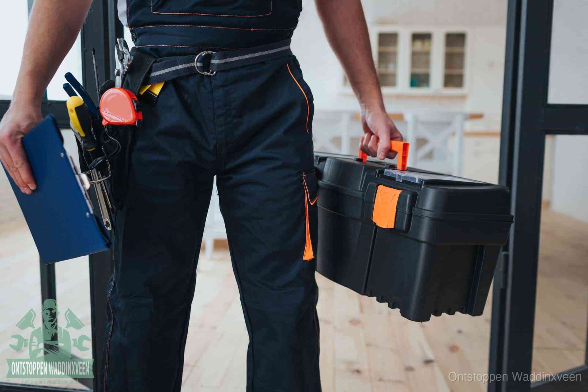 Een monteur met gereedschapsriem en klembord, klaar om een transparante prijs voor het afvoer ontstoppen in Waddinxveen te geven