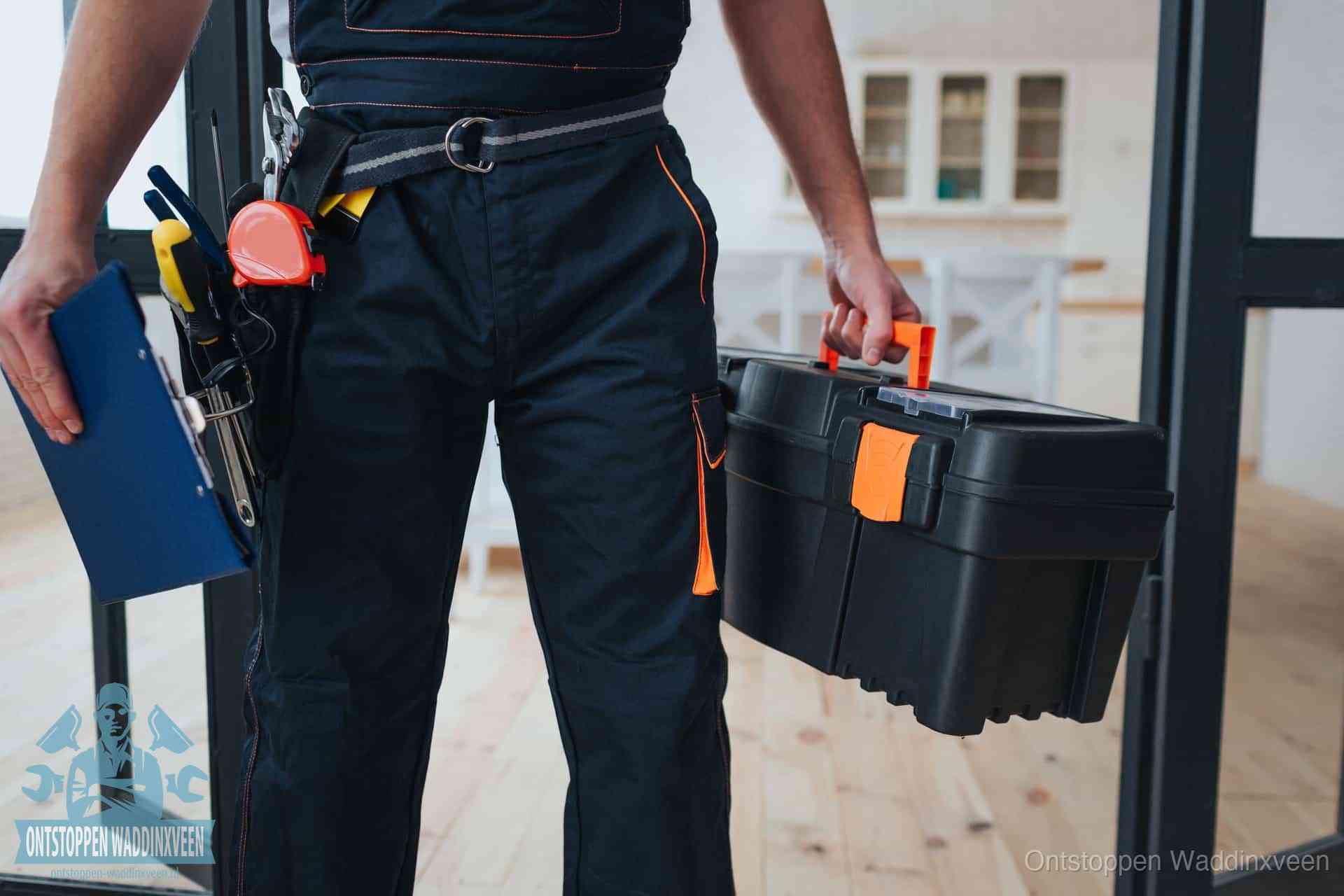 Een monteur met gereedschapsriem en klembord, klaar om een transparante prijs voor het wc ontstoppen in Waddinxveen te geven