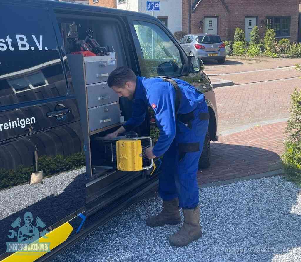 Een monteur pakt apparatuur uit de bedrijfsbus voor service aan huis, het moment om een professional in te schakelen voor een verstopte wc in Waddinxveen