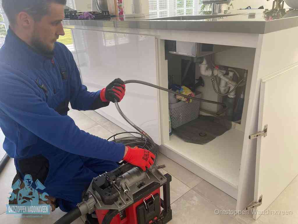 Een monteur reinigt de keukenafvoer grondig met een veermachine om terugkerende gootsteenverstoppingen te voorkomen in Waddinxveen