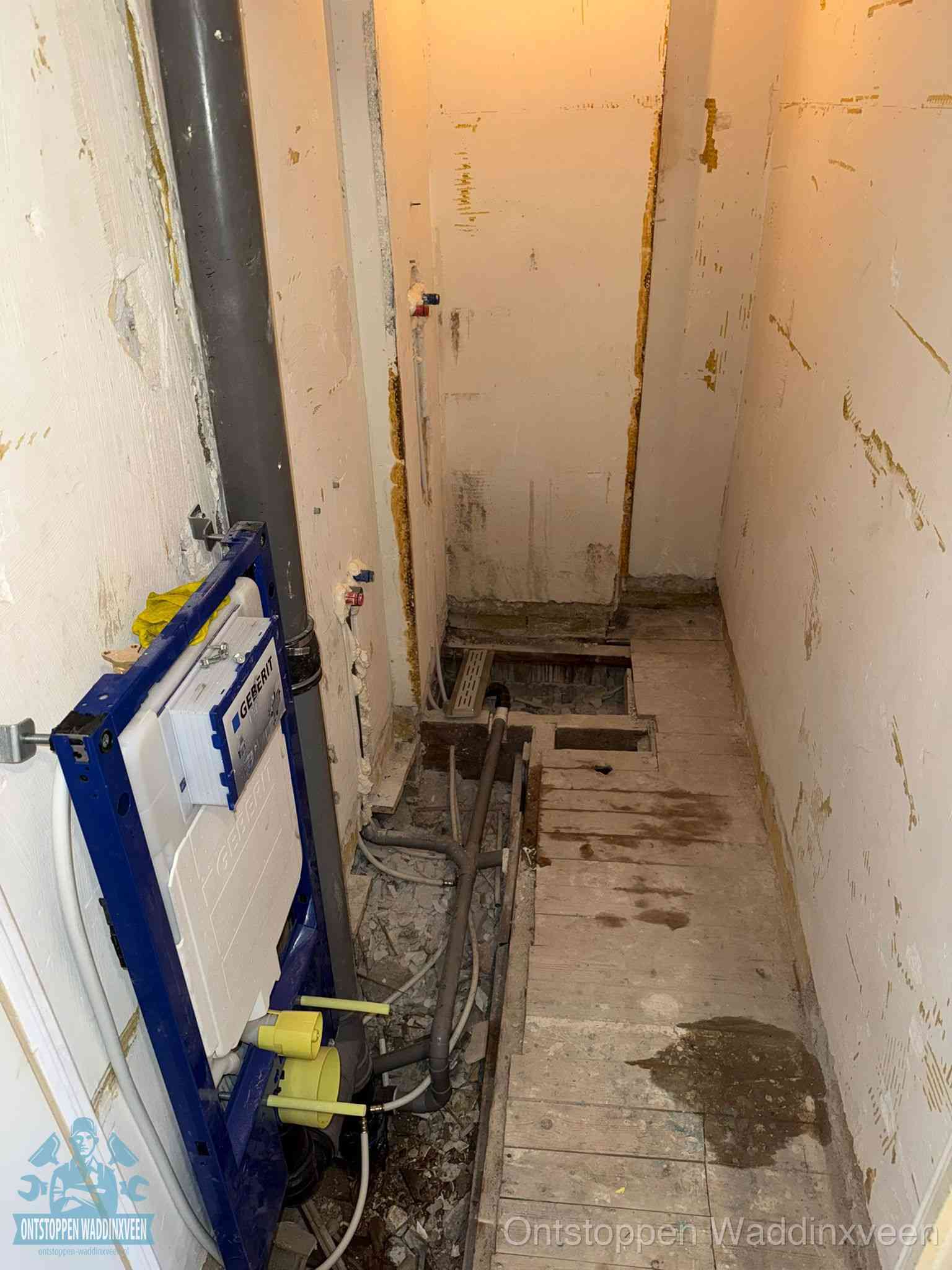 Een opgebroken toiletruimte tijdens renovatie met een Geberit inbouwreservoir en blootliggende oude afvoerleidingen, typisch voor oudere woningen in Waddinxveen